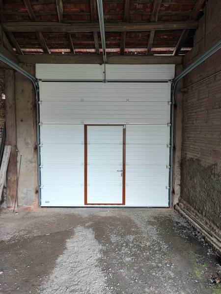 Porte de garage sectionnelle motorisée en imitation bois avec portillon intégré à Bruguières (31150) Toulouse