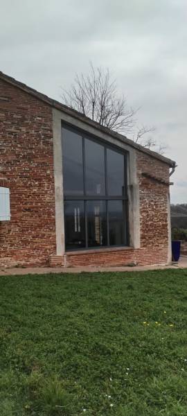 Pose sur mesure d’une grande baie vitrée trapèze dans une maison toulousaine