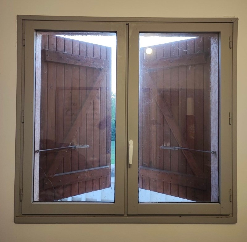 Fenêtre grise double vitrage et volets battants en bois : l’alliance parfaite entre modernité et tradition. Chantier réalisé à Saint-Jory (31790)